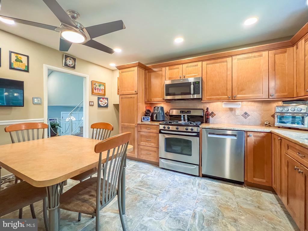 623 Kismet Road Philadelphia, PA 19115 - Photo 7 of 24 a kitchen with stainless steel appliances a stove a sink dishwasher a dining table and chairs