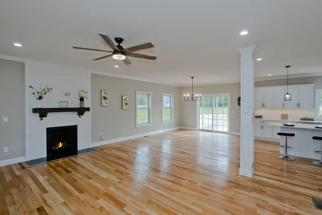 a view of empty room with wooden floor and fireplace