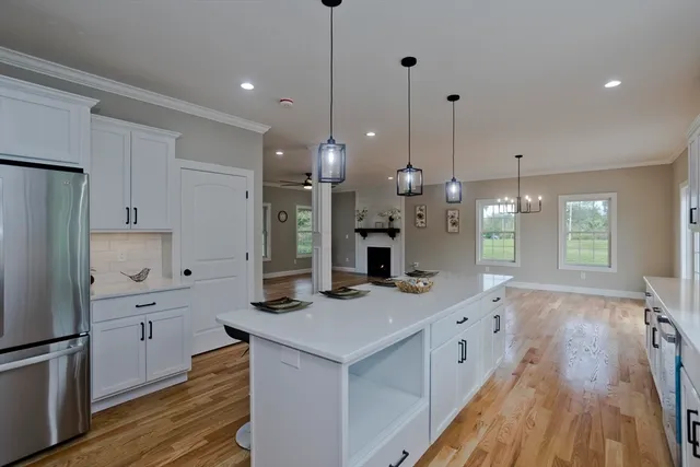 a kitchen with white cabinets appliances and wooden floor