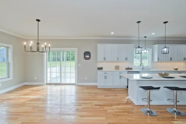 a kitchen with stainless steel appliances granite countertop a stove a sink dishwasher and a wooden cabinets with wooden floor