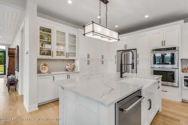 a kitchen with white cabinets and refrigerator