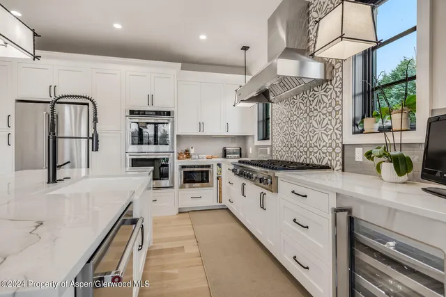 a kitchen with white cabinets and appliances