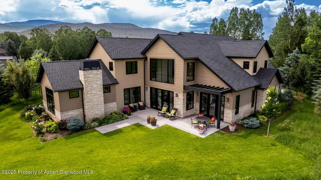 a aerial view of a house with table and chairs under an umbrella