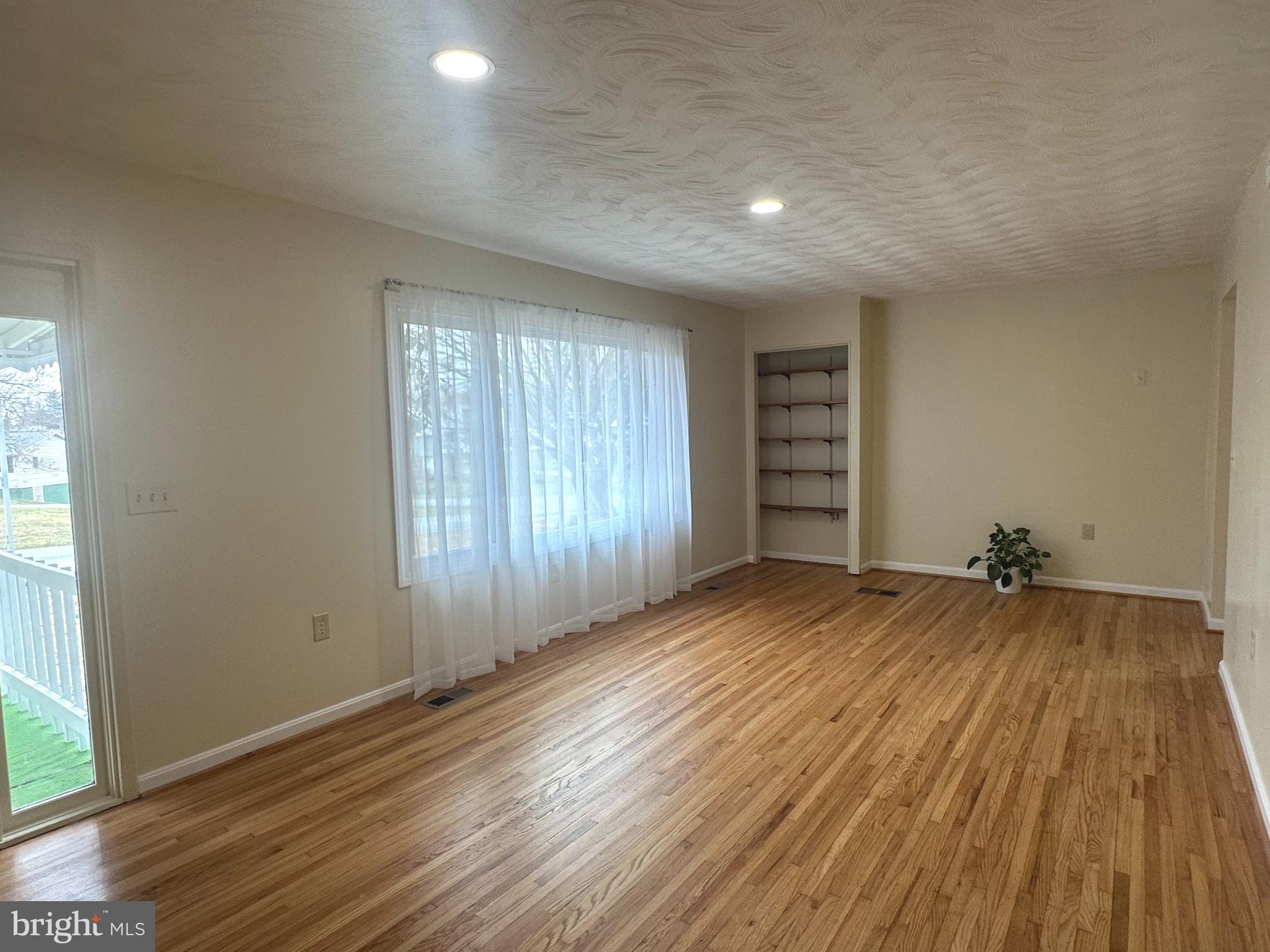 814 North Reymann Street Ranson, WV 25438 - Photo 9 of 19 an empty room with wooden floor and windows
