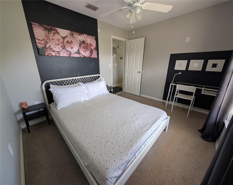 1675 Judith Drive, Unit A Kissimmee, FL 34758 - Photo 16 of 24 a bed sitting in a bedroom and chair