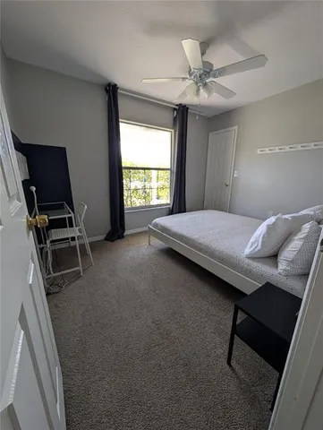 a bedroom with a bed and a ceiling fan