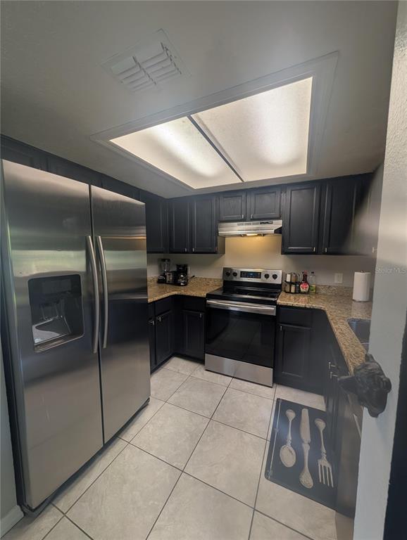 1675 Judith Drive, Unit A Kissimmee, FL 34758 - Photo 24 of 24 a kitchen with granite countertop a refrigerator and a stove top oven