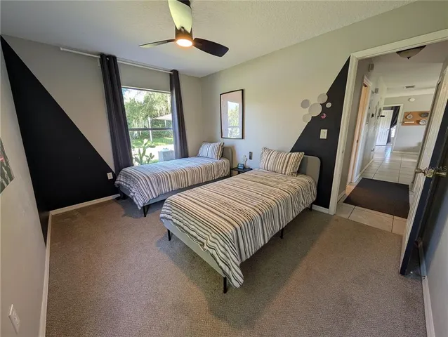 a spacious bedroom with two beds and a chandelier