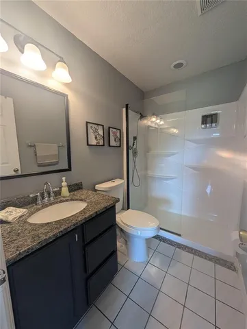 a bathroom with a granite countertop sink mirror vanity and toilet
