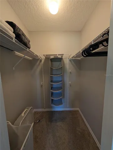 a view of walk in closet with clothes