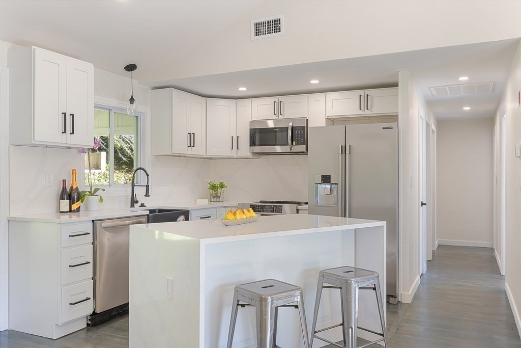 a kitchen with a sink a stove a refrigerator and cabinets