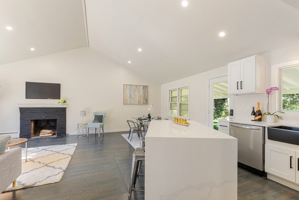 45 Revere Road Woburn, MA 01801 - Photo 12 of 32 a living room with furniture a fireplace and kitchen view