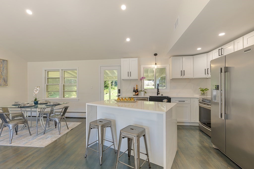 45 Revere Road Woburn, MA 01801 - Photo 13 of 32 a kitchen with stainless steel appliances granite countertop a table chairs refrigerator a sink a stove a dining table and chairs