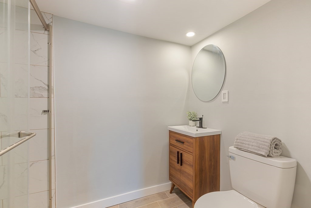 45 Revere Road Woburn, MA 01801 - Photo 24 of 32 a bathroom with a toilet sink vanity and mirror