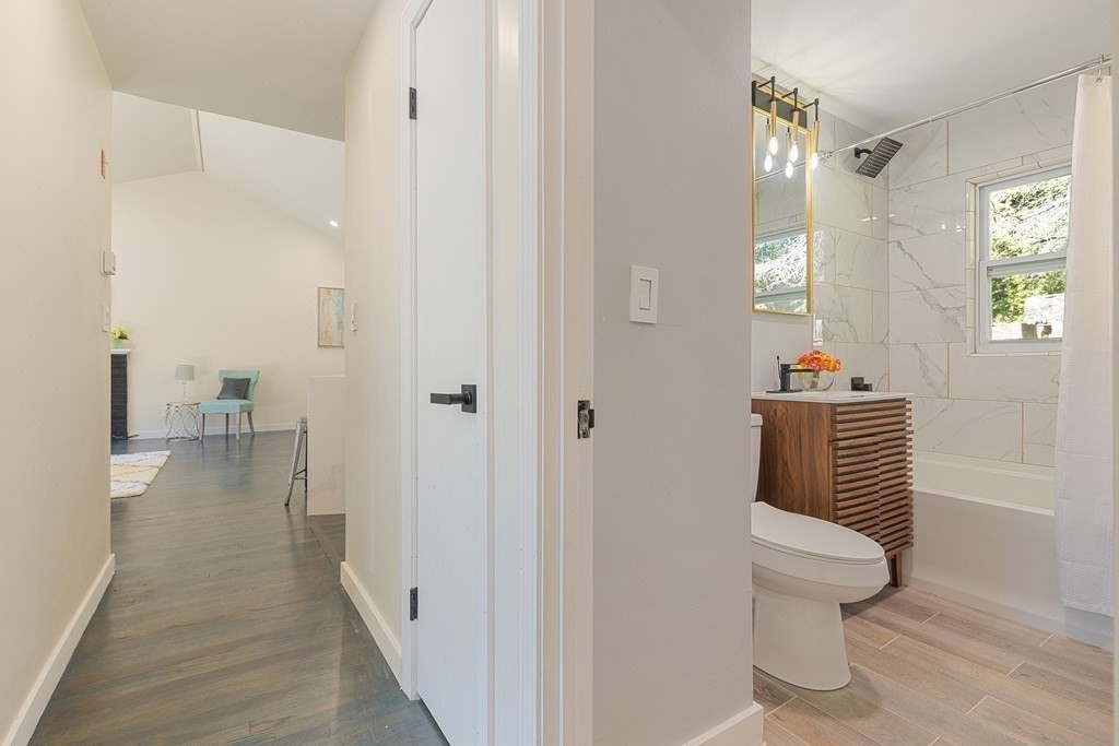 45 Revere Road Woburn, MA 01801 - Photo 9 of 32 a view of a hallway with wooden floor and a bathroom