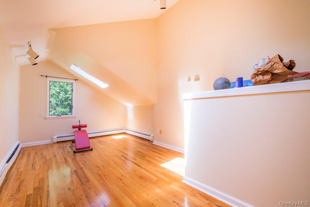 64 Furnace Woods Road Cortlandt Manor, NY 10567 - Photo 13 of 38 Additional living space with hardwood flooring, and vaulted ceiling with skylight. Potential usage includes home office, gym, or den.