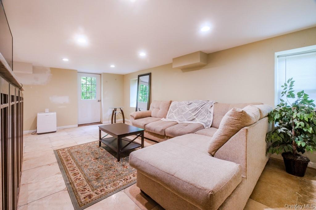 64 Furnace Woods Road Cortlandt Manor, NY 10567 - Photo 23 of 38 Second living room with light tile flooring, full bathroom, and walkout to backyard.