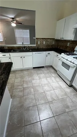 a white kitchen with a sink a vanity and appliances