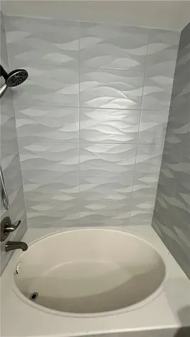 a bathroom with a double vanity sink a mirror and a bathtub