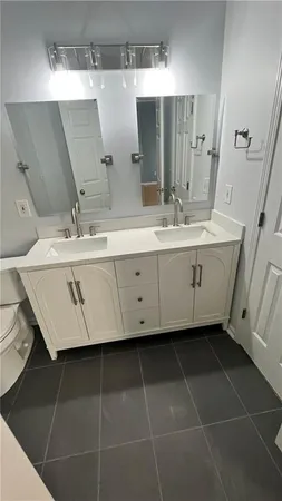 a bathroom with a double vanity sink toilet and shower