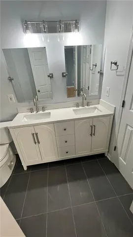 a bathroom with a double vanity sink toilet and shower