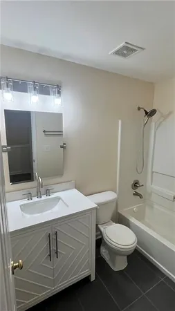 a bathroom with a granite countertop sink a toilet and shower