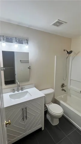 a bathroom with a granite countertop sink a toilet and shower