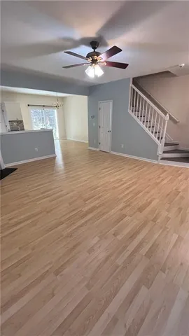 a view of an empty room with a chandelier fan