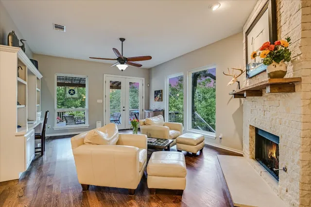a living room with furniture fireplace and large windows