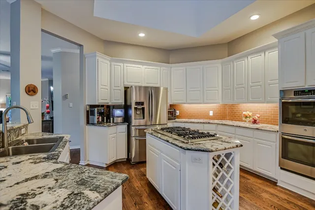 a kitchen with stainless steel appliances granite countertop a stove refrigerator sink and microwave