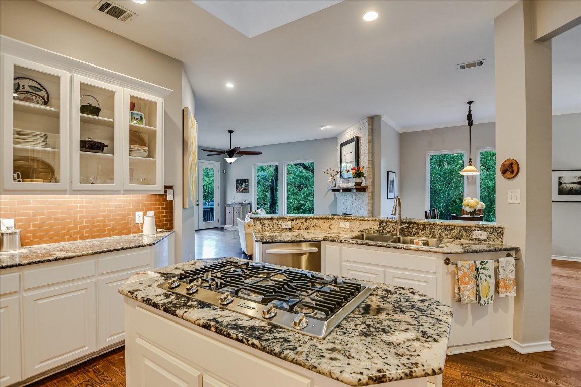 5507 Mt Bonnell Road Austin, TX 78731 - Photo 17 of 35 a kitchen with stainless steel appliances kitchen island granite countertop a stove and white cabinets