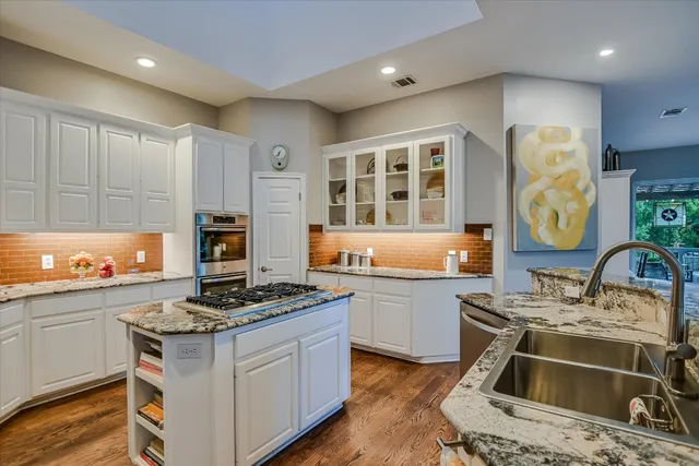 a kitchen with stainless steel appliances granite countertop a stove and a sink