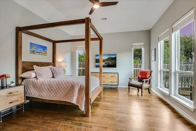 a bedroom with a bed and large windows