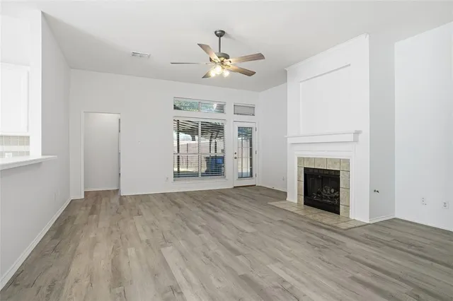 a view of empty room with wooden floor and fireplace
