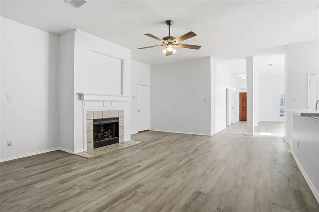 a view of a livingroom with wooden floor and a fireplace