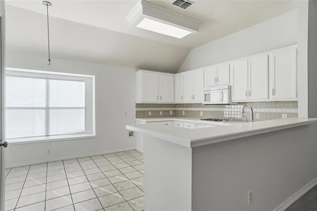 a kitchen with white cabinets appliances and a sink