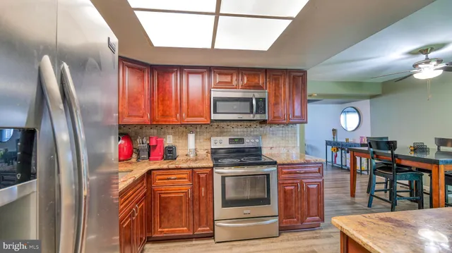 a kitchen with stainless steel appliances granite countertop a refrigerator stove and sink