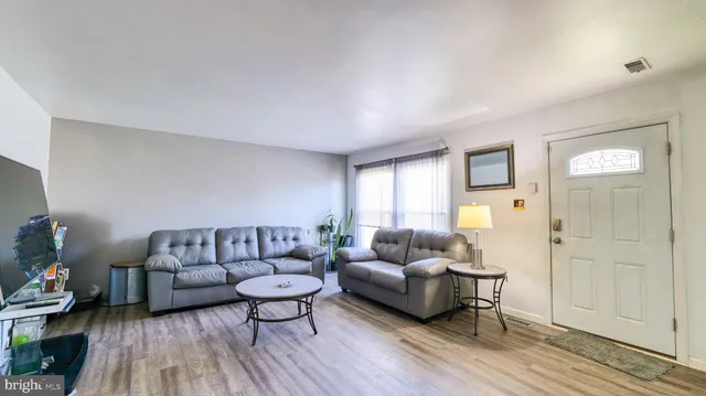 a living room with furniture and a wooden floor
