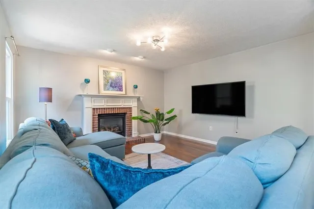 a living room with furniture a fireplace and a flat screen tv