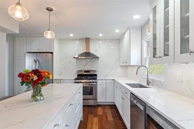 a kitchen with stainless steel appliances granite countertop sink stove and cabinets