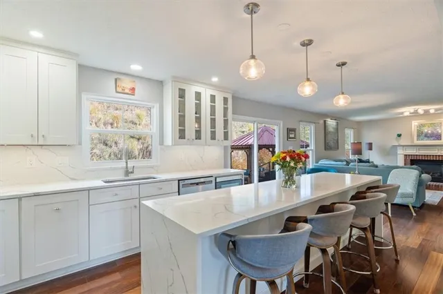 a kitchen with stainless steel appliances granite countertop a kitchen island a table and chairs in it