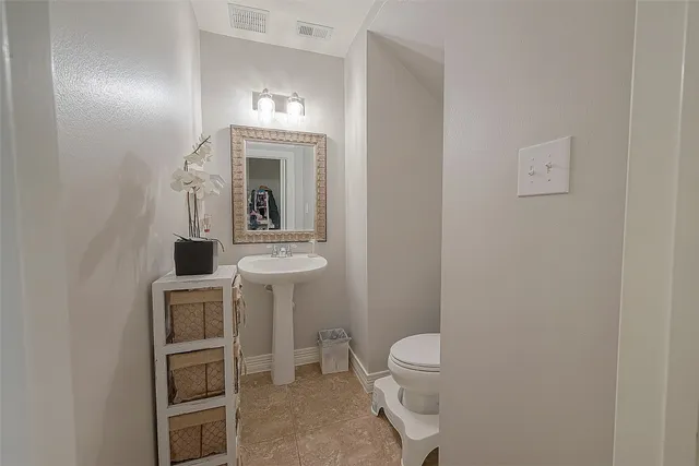 a bathroom with a toilet a sink and mirror