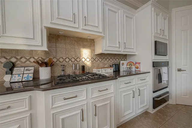 a kitchen with granite countertop a refrigerator stove and sink