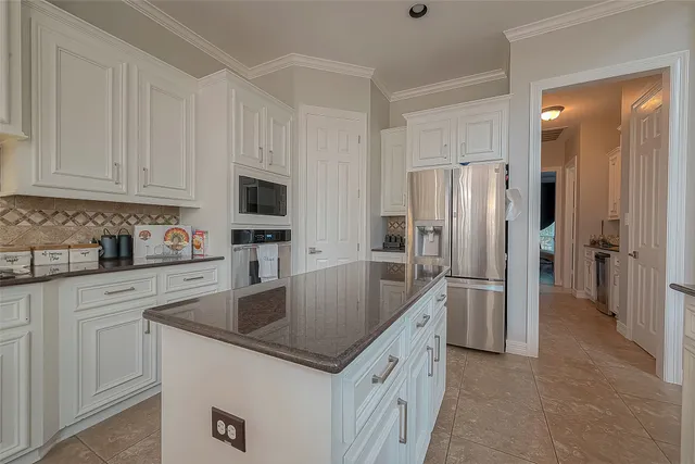 a kitchen with granite countertop white cabinets and stainless steel appliances