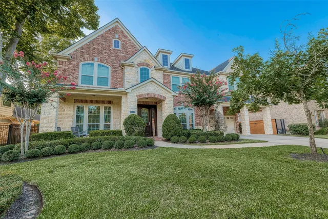 a front view of a house with a yard and trees