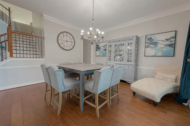 a view of a dining room with furniture a chandelier and wooden floor