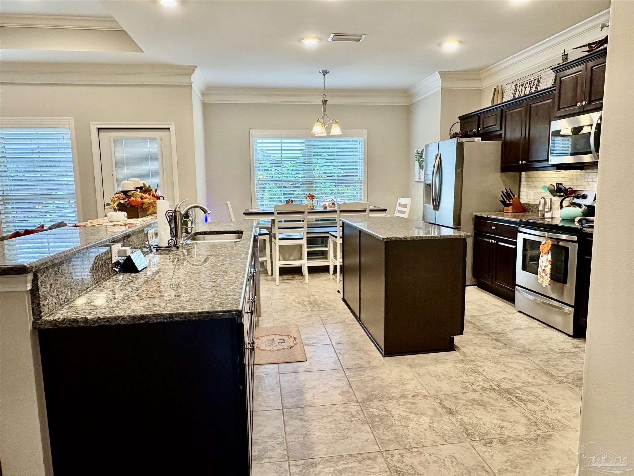 1700 Kahuna Way Cantonment, FL 32533 - Photo 13 of 34 a kitchen with stainless steel appliances granite countertop a stove refrigerator and a sink