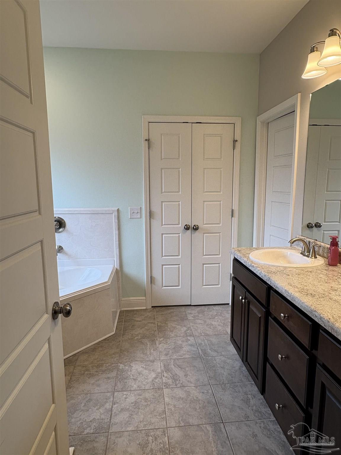 1700 Kahuna Way Cantonment, FL 32533 - Photo 23 of 34 a bathroom with a granite countertop sink a mirror and a bathtub