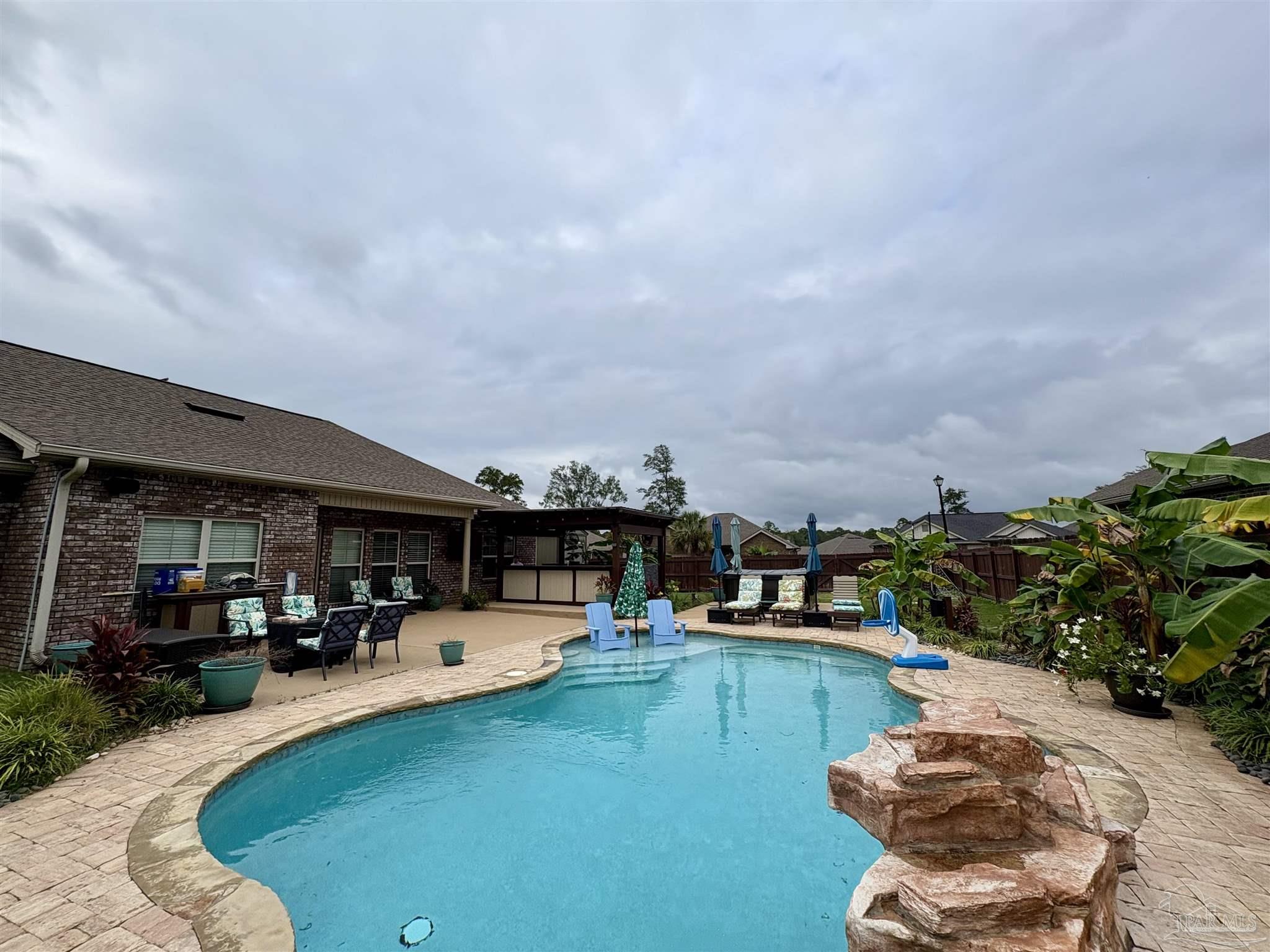 1700 Kahuna Way Cantonment, FL 32533 - Photo 33 of 34 a swimming pool with outdoor seating and a garden