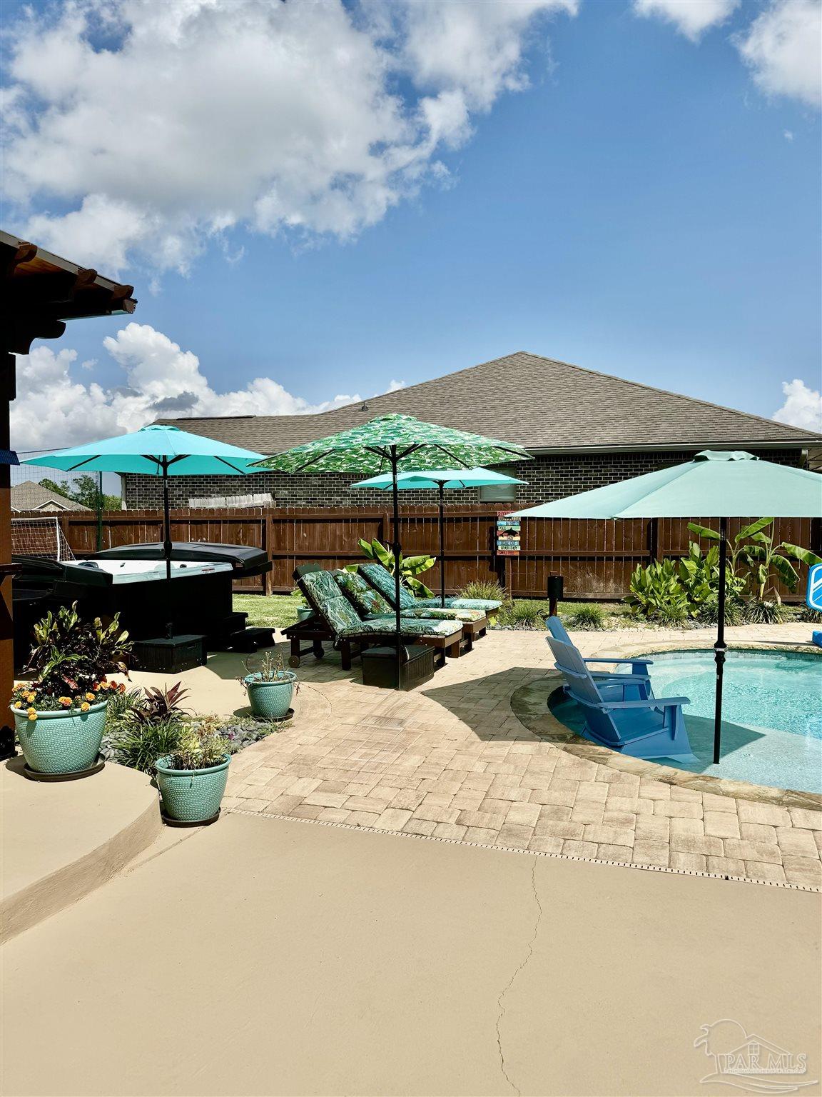 1700 Kahuna Way Cantonment, FL 32533 - Photo 9 of 34 a view of a patio with table and chairs under an umbrella